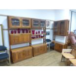 A 1980's Danish designed solid teak shelving system including five uprights, three glazed cabinets,