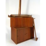 A 1970's teak modular shelving system including four uprights, two cabinet and various shelves,