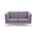 A 1970's two seater sofa with lilac upholstery on oak square straight legs