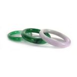 Two green jade bangles and a pale purple bangle,