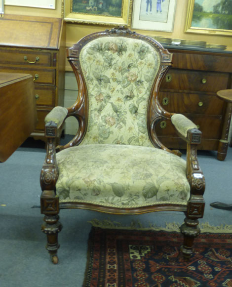 A Victorian mahogany and button upholstered open armchair on turned front legs