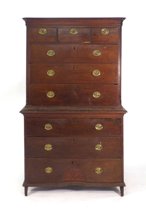 A George III oak chest on chest with an arrangement of three short and six long graduated drawers,