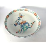 A Japanese porcelain dish centrally decorated in coloured enamels with an exotic bird resting on a