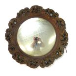 A late 19th century stained beech and gilt mirror, the circular mirror within a foliate frame, d.