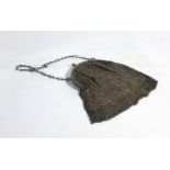 A silver mesh link evening purse suspended on an elongated link chain,