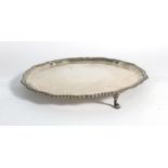 A Victorian silver salver of circular form having gadrooned border on three hoof feet,