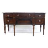 An early 19th century mahogany break-front sideboard with an arrangement of four drawers and a