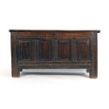 An 18th century oak coffer with panelled front, lid and sides on square straight stiles, l.
