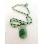 A pale green jade oval bead necklace suspending a seed shaped pendant, pendant l. 4.