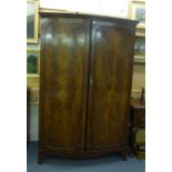 A late 19th century mahogany bow fronted wardrobe, the two doors enclosing a rail over four drawers,