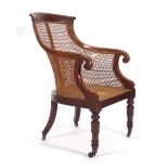 A William IV mahogany and bergere open armchair with scrolled arms and turned front legs with