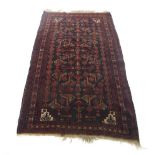 A late 19th century rug, the dark red ground with geometric motifs within stylised bands,