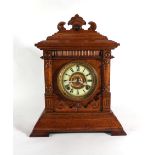 A late 19th century American mantle clock, the brass and enamelled face with Roman numerals,