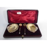 A cased pair of Victorian silver and parcel gilt salts of shell form and a pair of matching spoons,