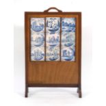 A 1920's oak firescreen inset with nine Delft tiles CONDITION REPORT: Damage to