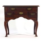 A mahogany and walnut lowboy, the four drawers over a shaped apron on cabriole legs, w.