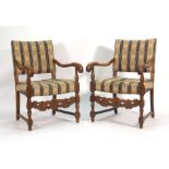 A pair of 17th century-type oak and upholstered hall armchairs with carved stretchers
