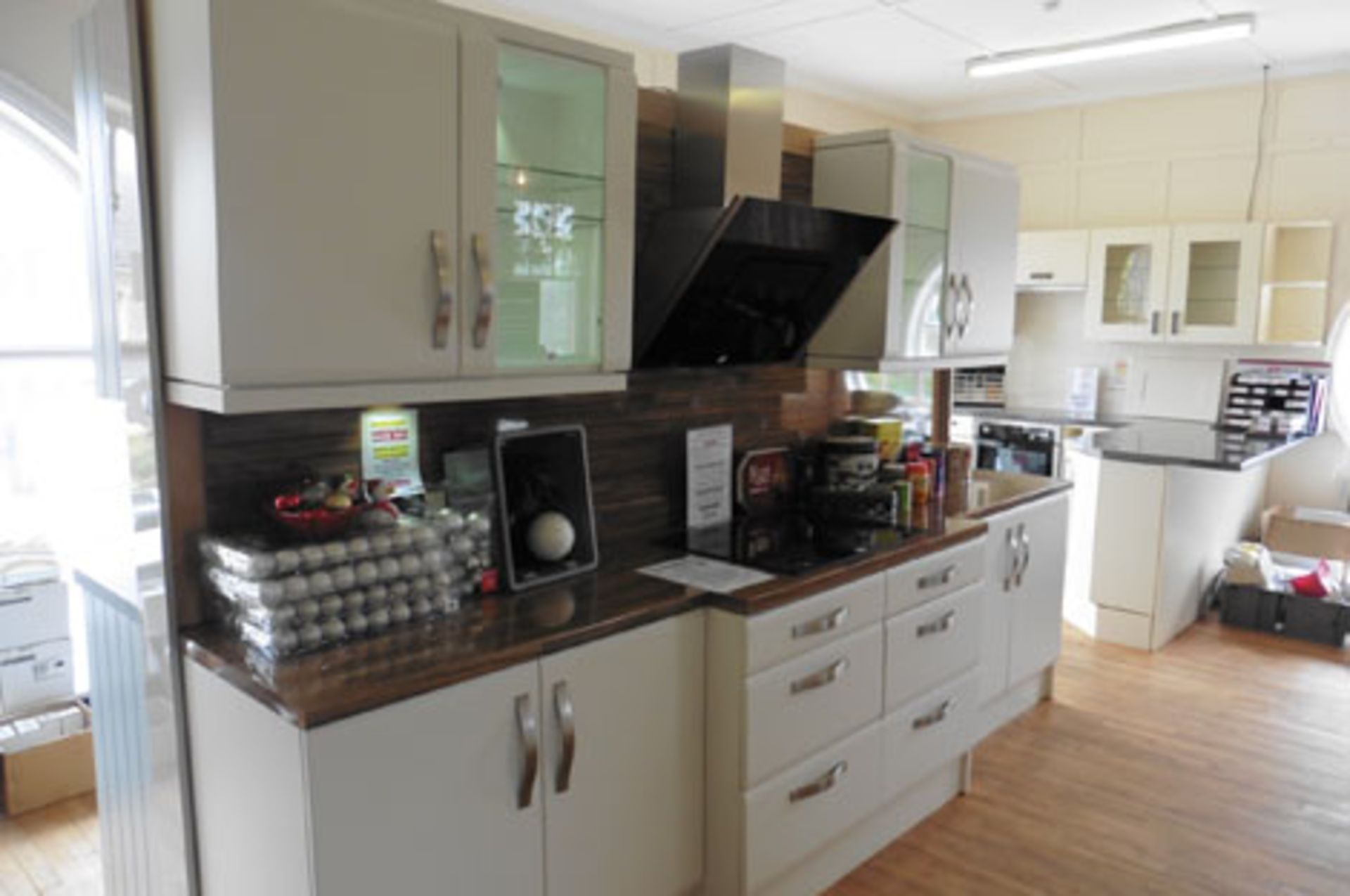 Kitchen display in white with brushed chrome handles, illuminated cabinets, soft closer drawers