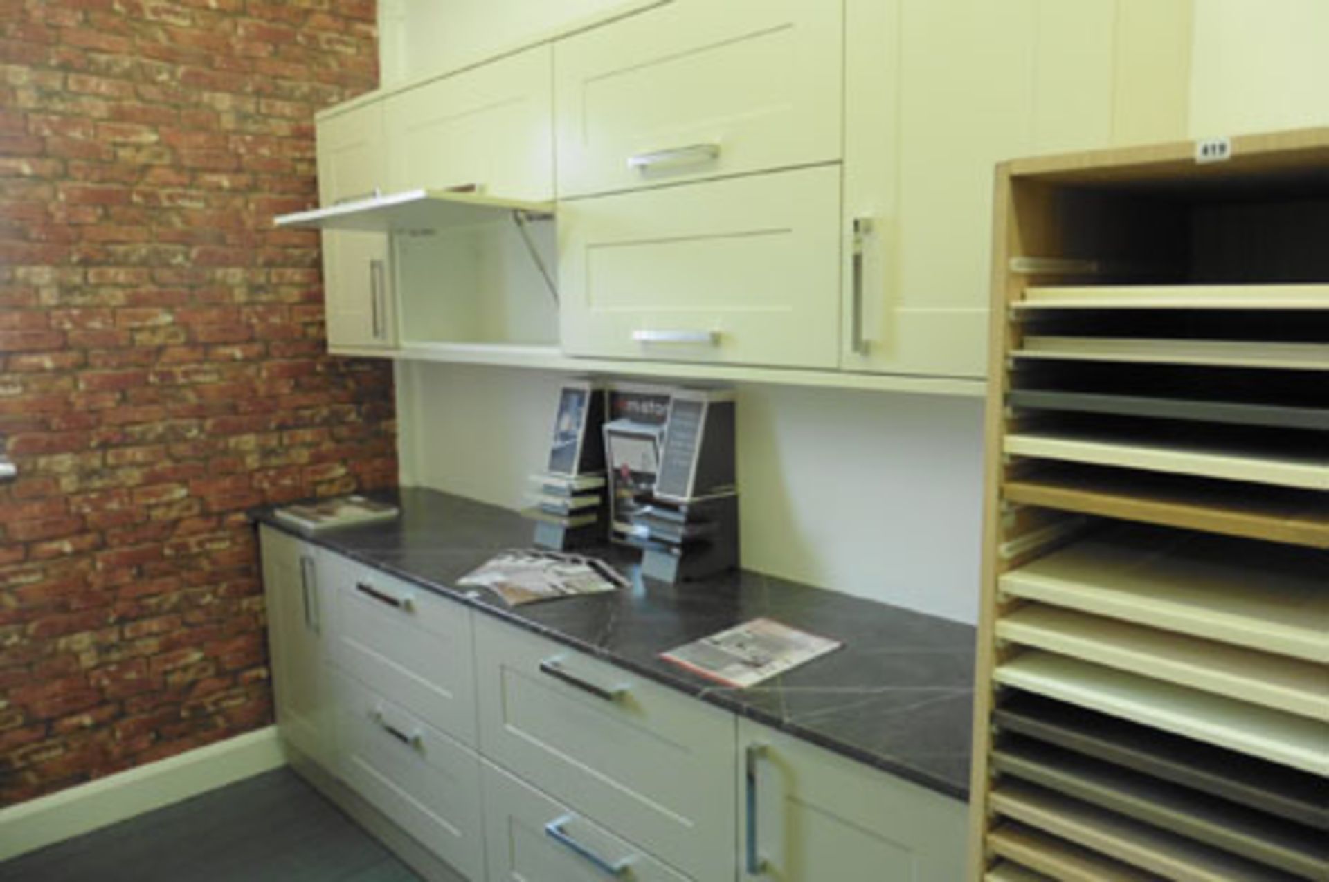 A grey and cream kitchen display with a slate effect worktop, approximate length 258cm