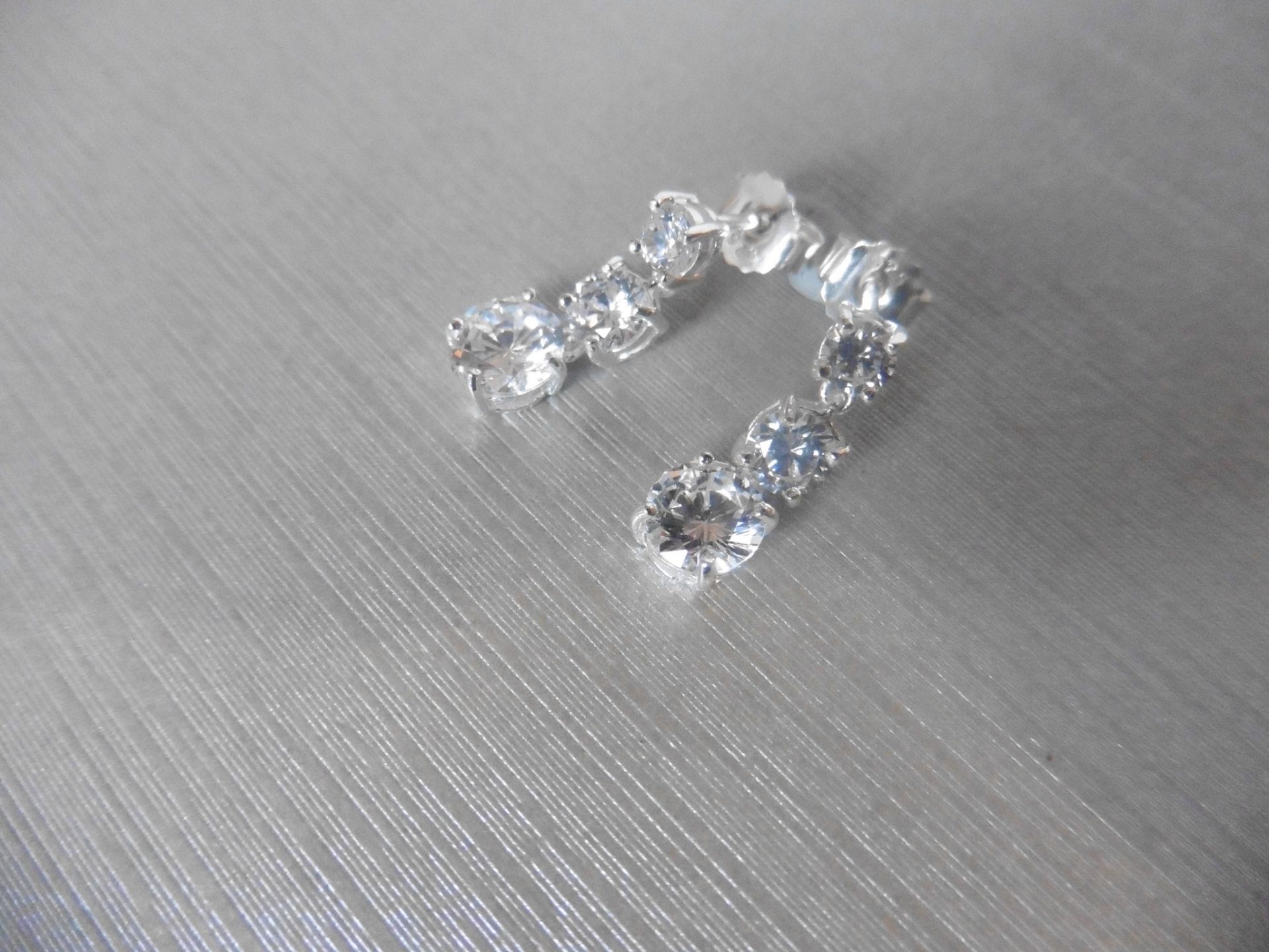 1.20ct diamond trilogy drop earrings. Each is set with 3 graduated brilliant cut diamonds, Si2