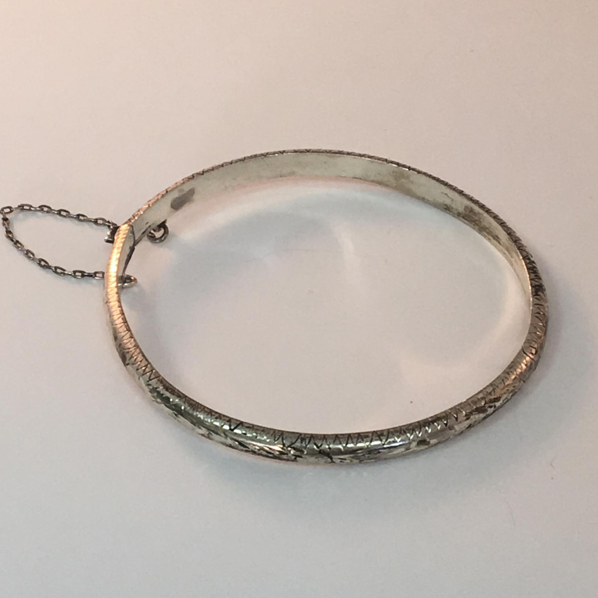Vintage silver hinged bangle with safety chain, stamped 925