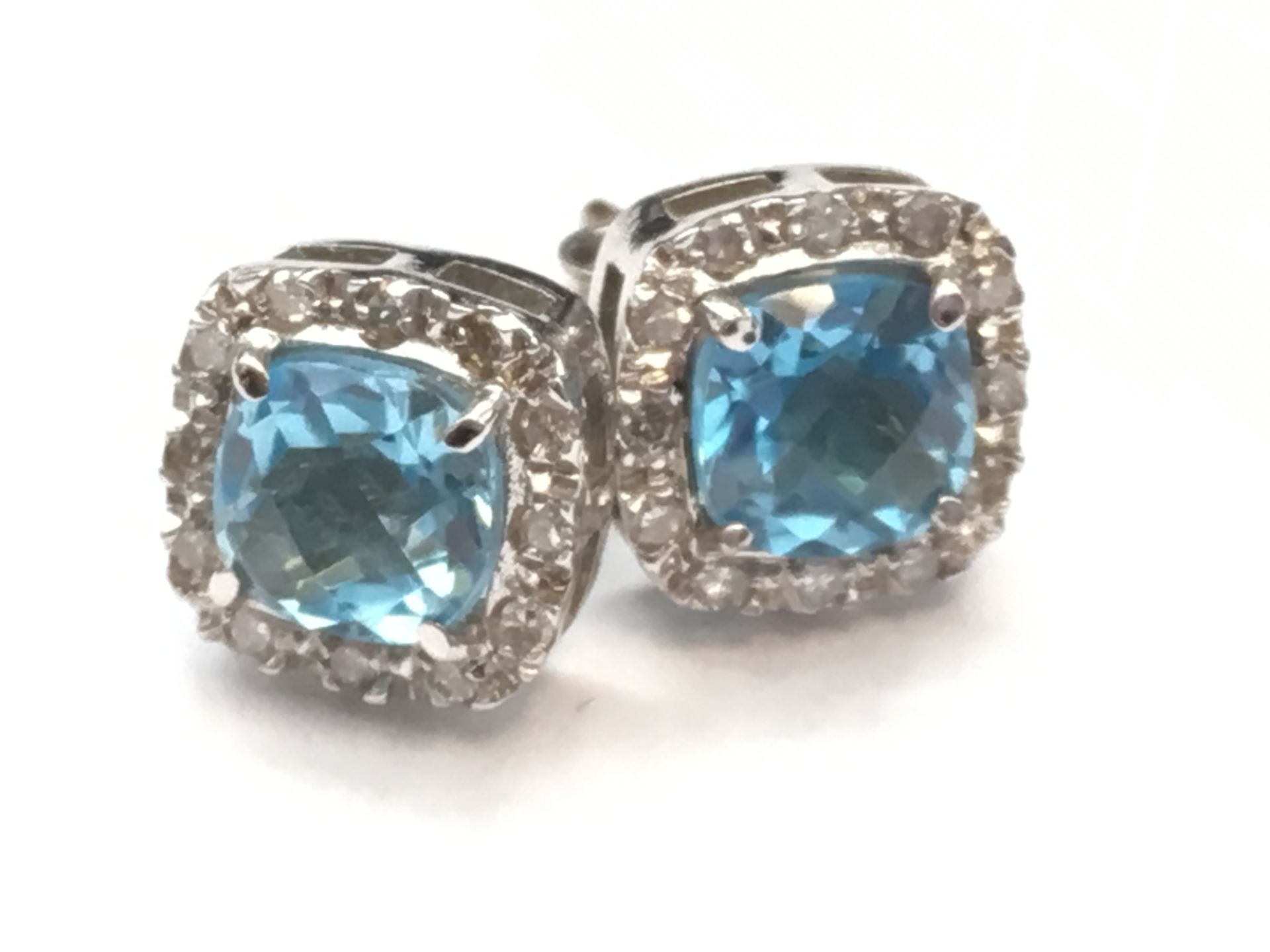 Pair of ladies gold and diamond earrings set with a centre blue topaz