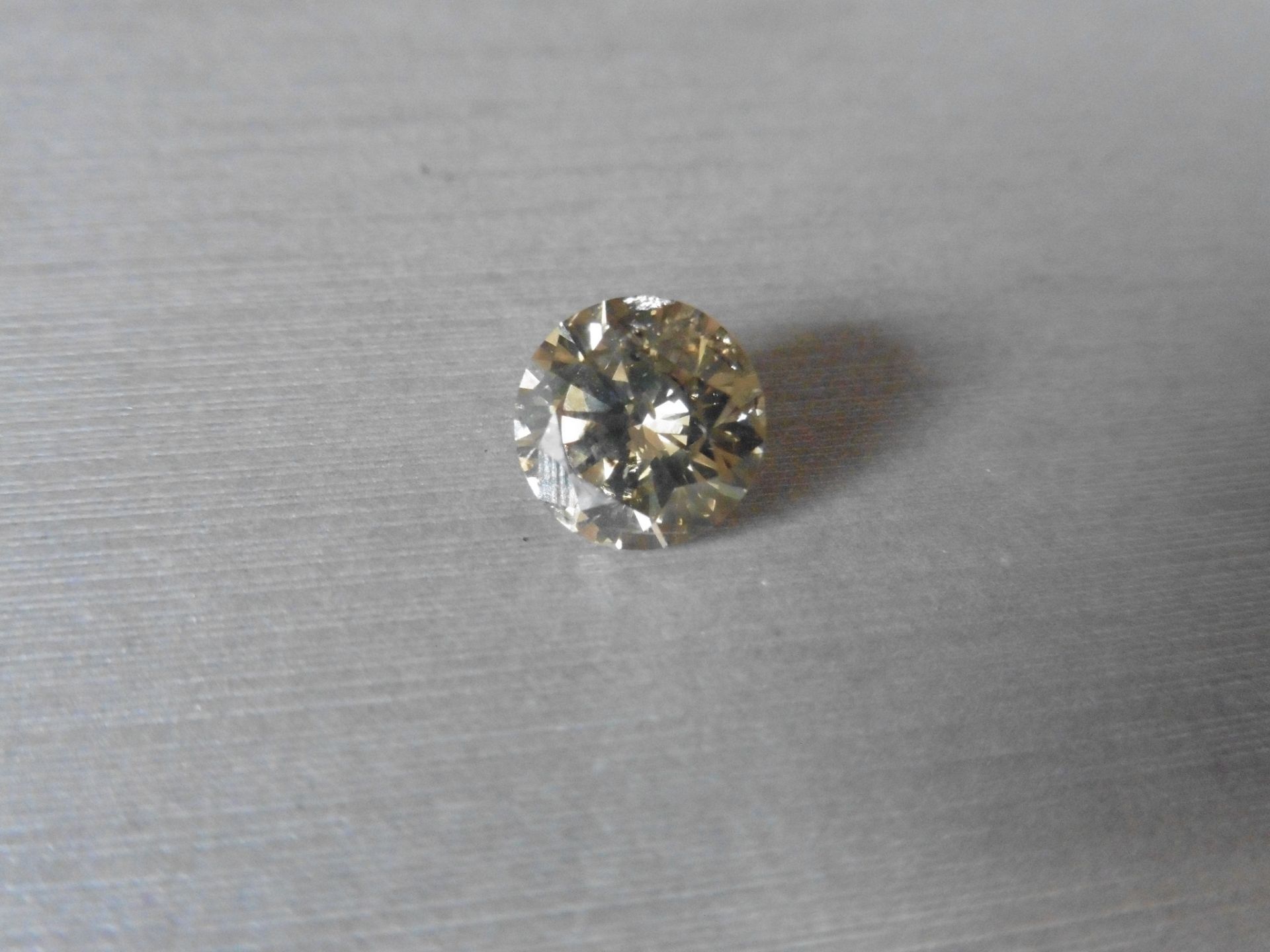 3.04ct single brilliant cut diamond. Measures 7.28 x 5.62mm. Colour – brown.