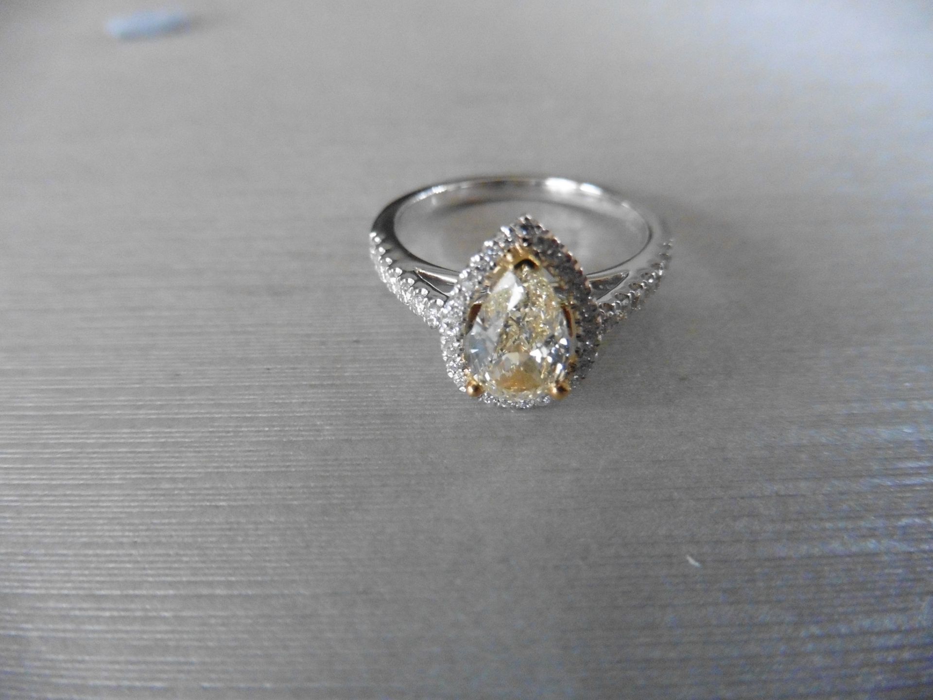 0.75ct yellow pear shaped diamond set solitaire ring. Has a halo setting of small brilliant cut