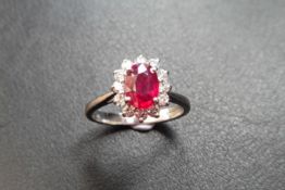 Ruby and diamond cluster style ring set in platinum. Oval cut ( treated ) ruby 0.80ct with 0.50ct of