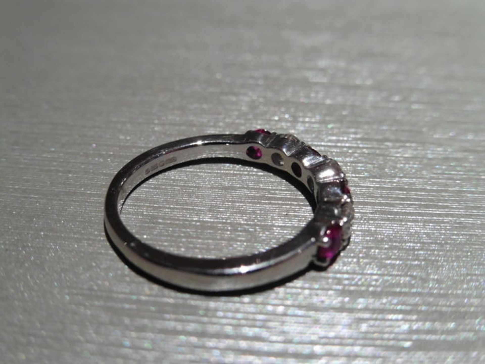 Ruby and diamond eternity band ring set in platinum. 4 round cut ( treated ) rubies and 3 - Image 3 of 3