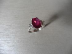 Ruby and diamond dress ring set in platinum. Oval cut ruby ( glass filled ) 2.40ct approx with 3