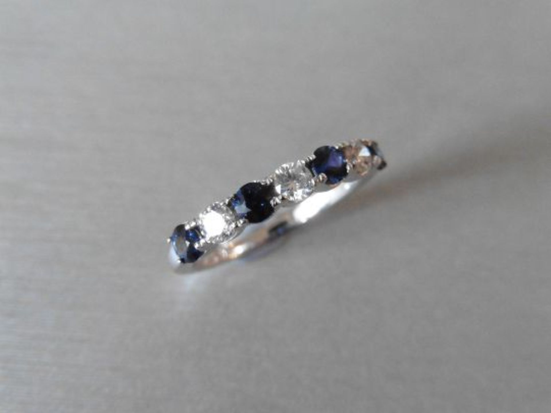 Sapphire and diamond eternity style ring. 4 round cut sapphires ( treated) 3 brilliant cut diamonds.