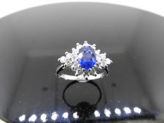 Sapphire and diamond cluster style ring set in platinum. Oval cut ( treated ) sapphire 0.80ct with