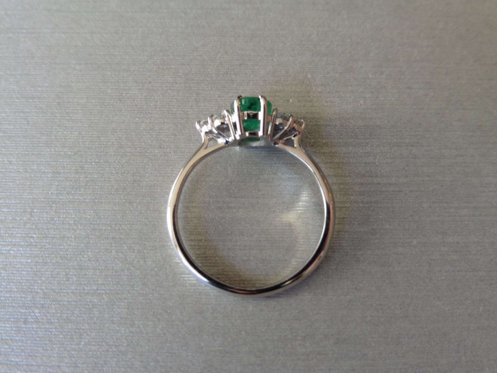 0.80ct emerald and diamond ring. Set with an oval cut emerald . Set either side are 3 small - Image 2 of 3
