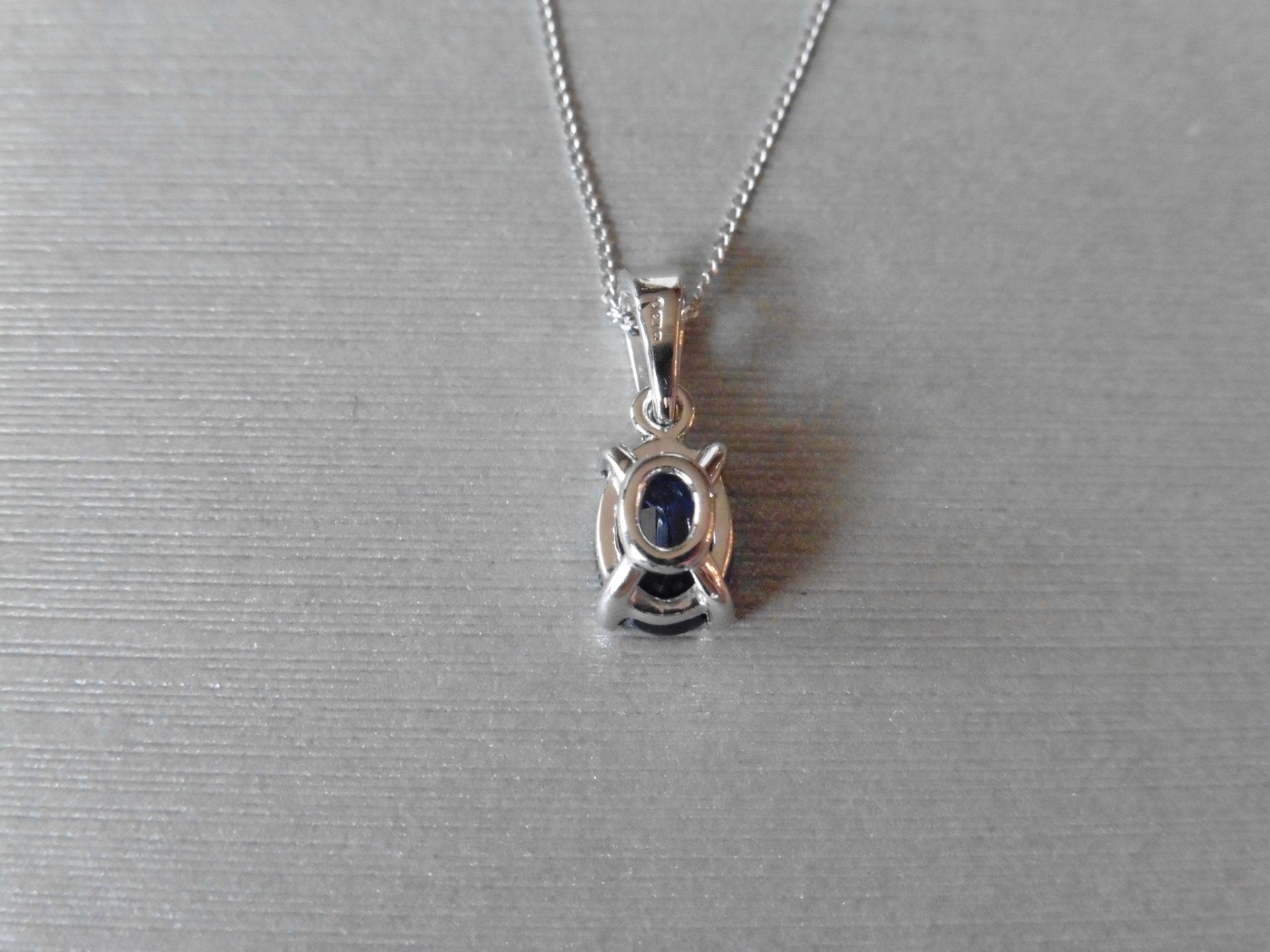 0.80ct Sapphire and diamond pendant. 7 x 5mm oval cut sapphire set in a four claw setting. The - Image 3 of 3