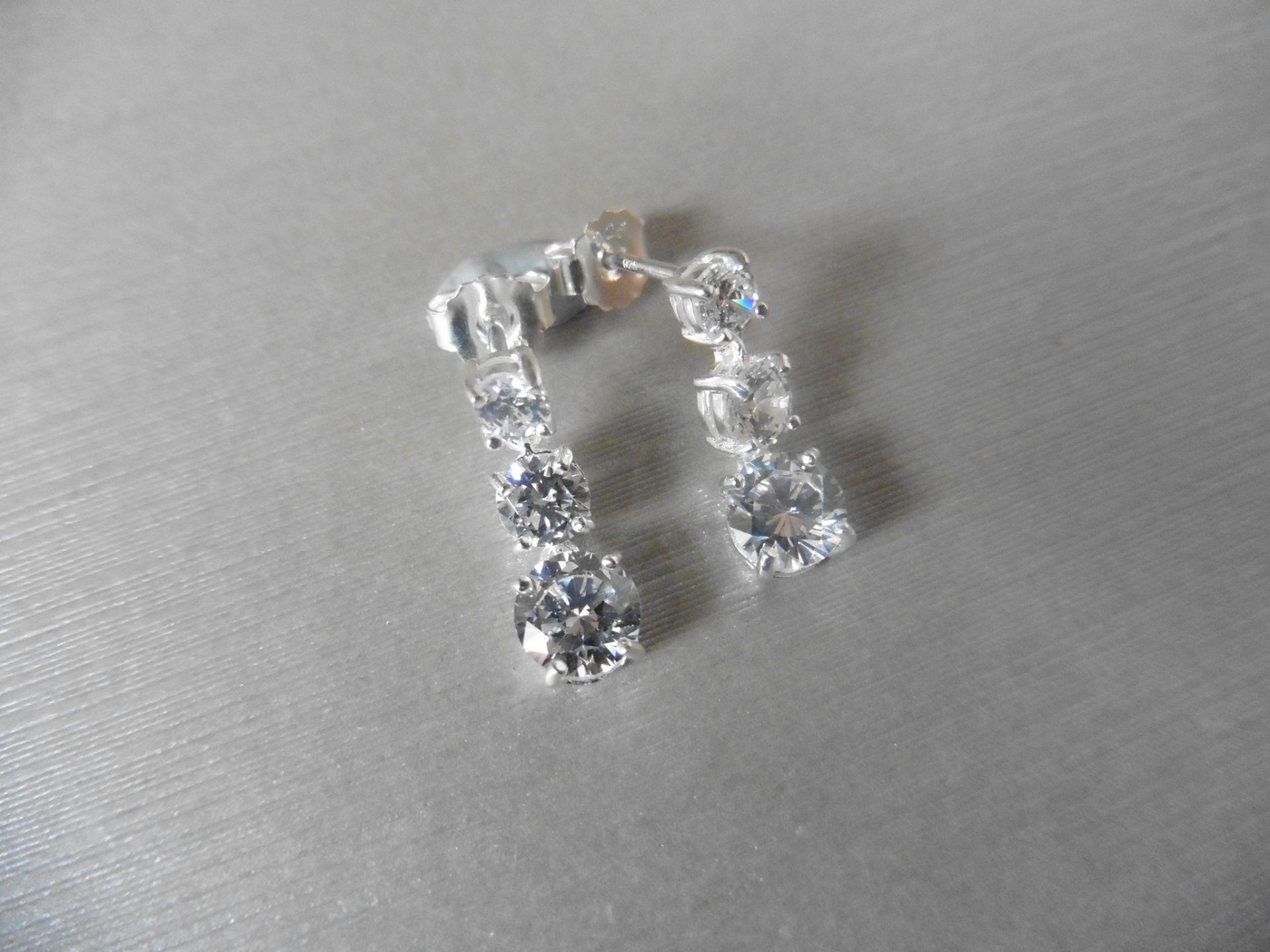 1.00ct diamond trilogy drop earrings. Each is set with 3 graduated brilliant cut diamonds, Si2
