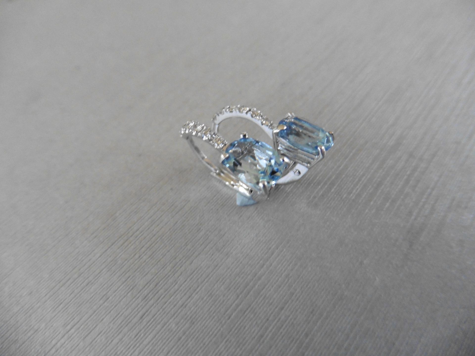 1.60ct Aqua marine and diamond hoop style earrings. Each is set with a 7x 5mm oval cut aqua with 6 - Image 2 of 4