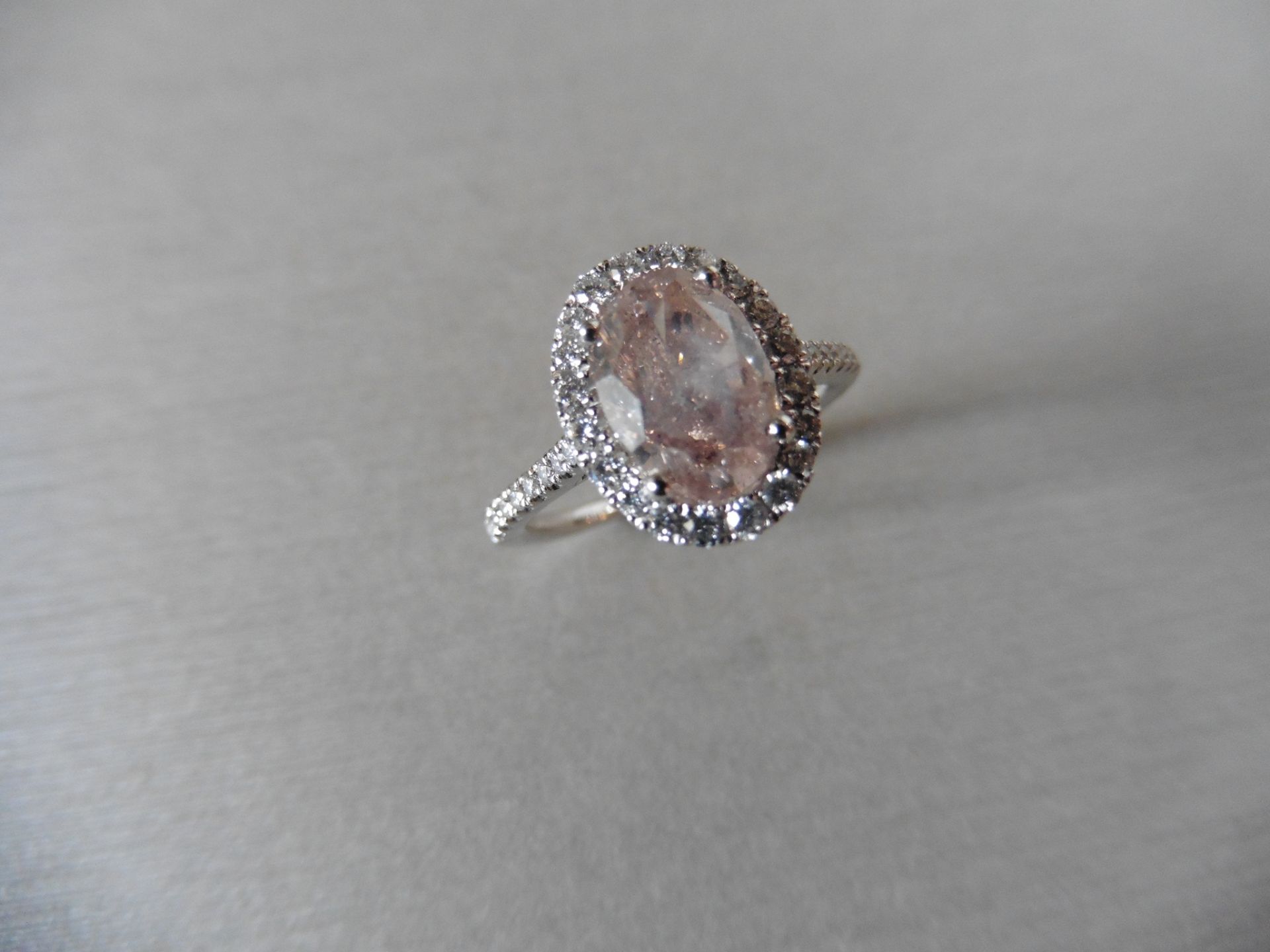 2.35ct diamond set ring with a 2ct pink/ brown oval shaped diamond. This is surrounded with a halo