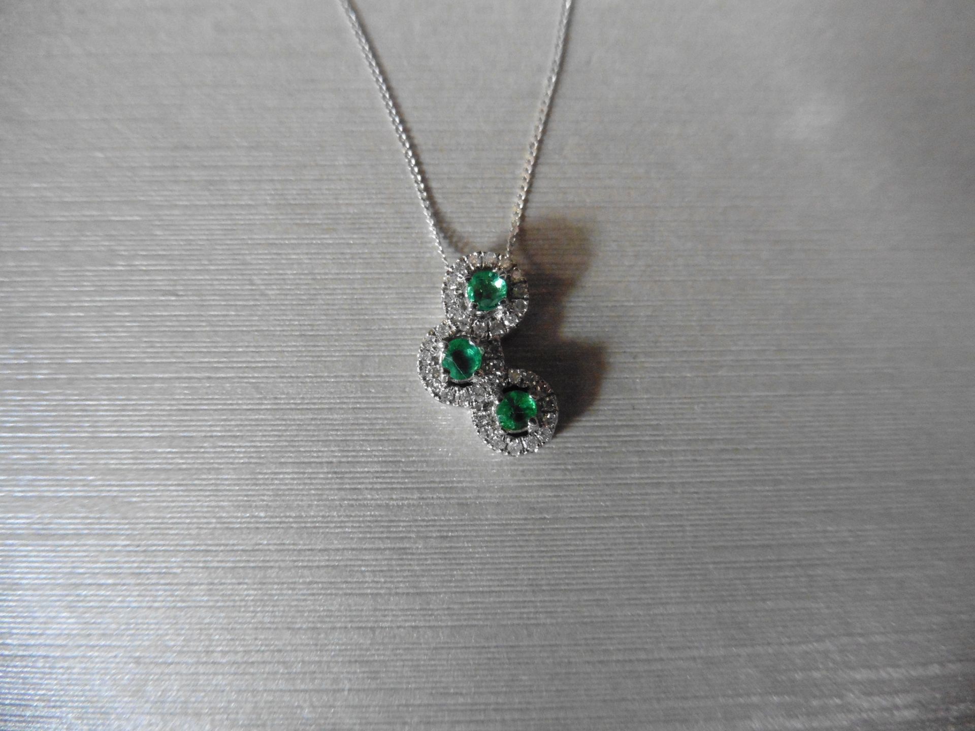 0.35ct diamond set halo trilogy style pendant. 3 centred emeralds 0.17ct total with halo setting 0.
