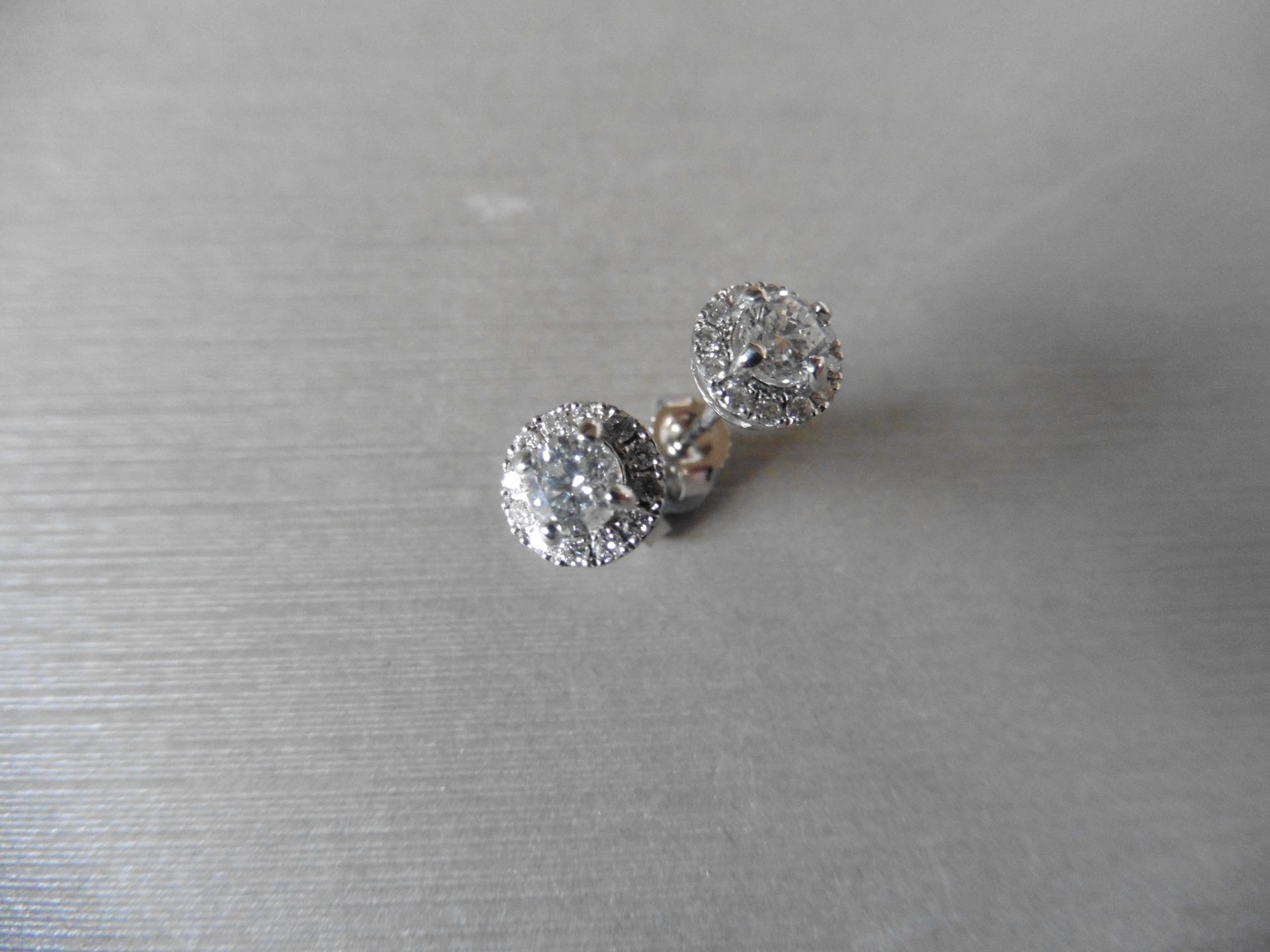 0.75ct diamond set stud style earrings. Centre stones 0.50ct total, I colour si2 clarity. Halo