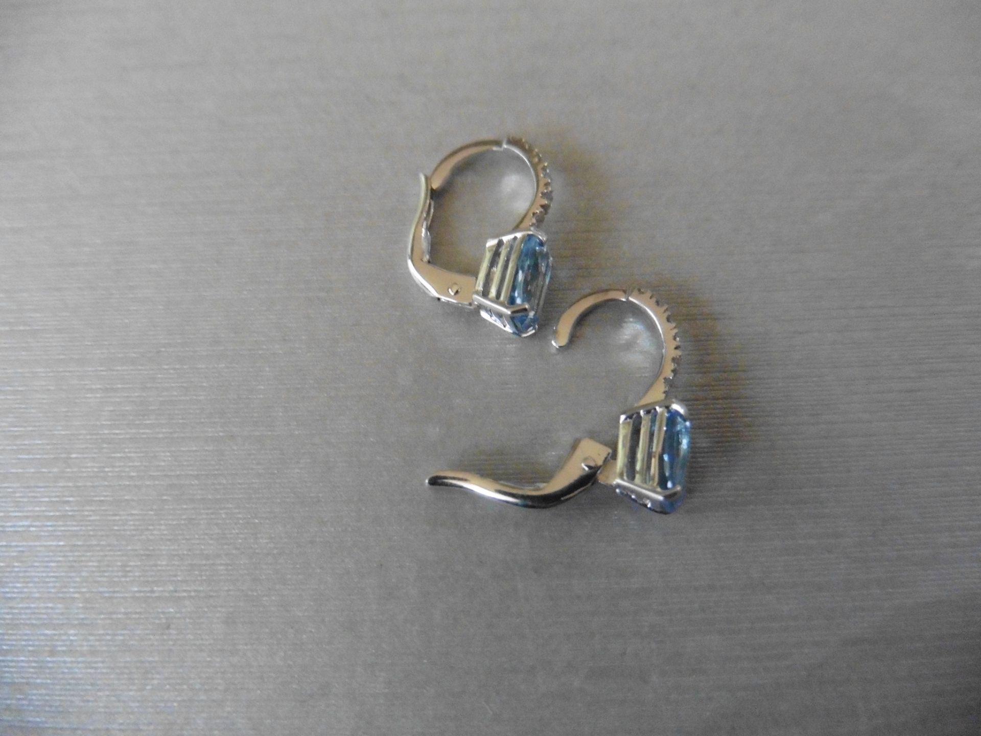 1.60ct Aqua marine and diamond hoop style earrings. Each is set with a 7x 5mm oval cut aqua with 6 - Image 3 of 4