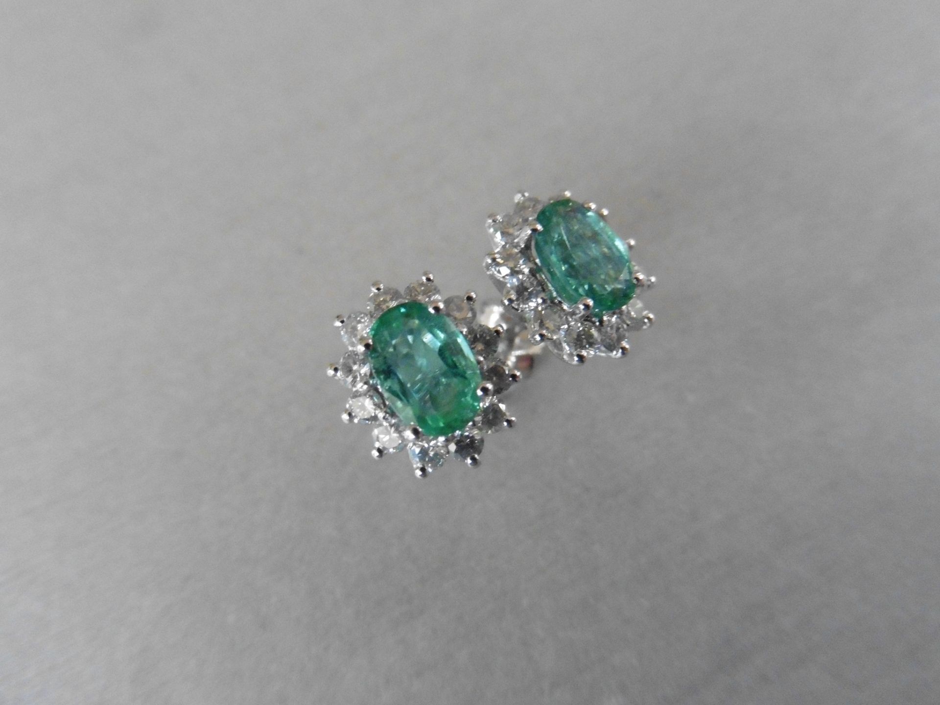 1.60ct emerald and Diamond cluster style stud earrings. Each emerald measures 7mm x 5mm and is