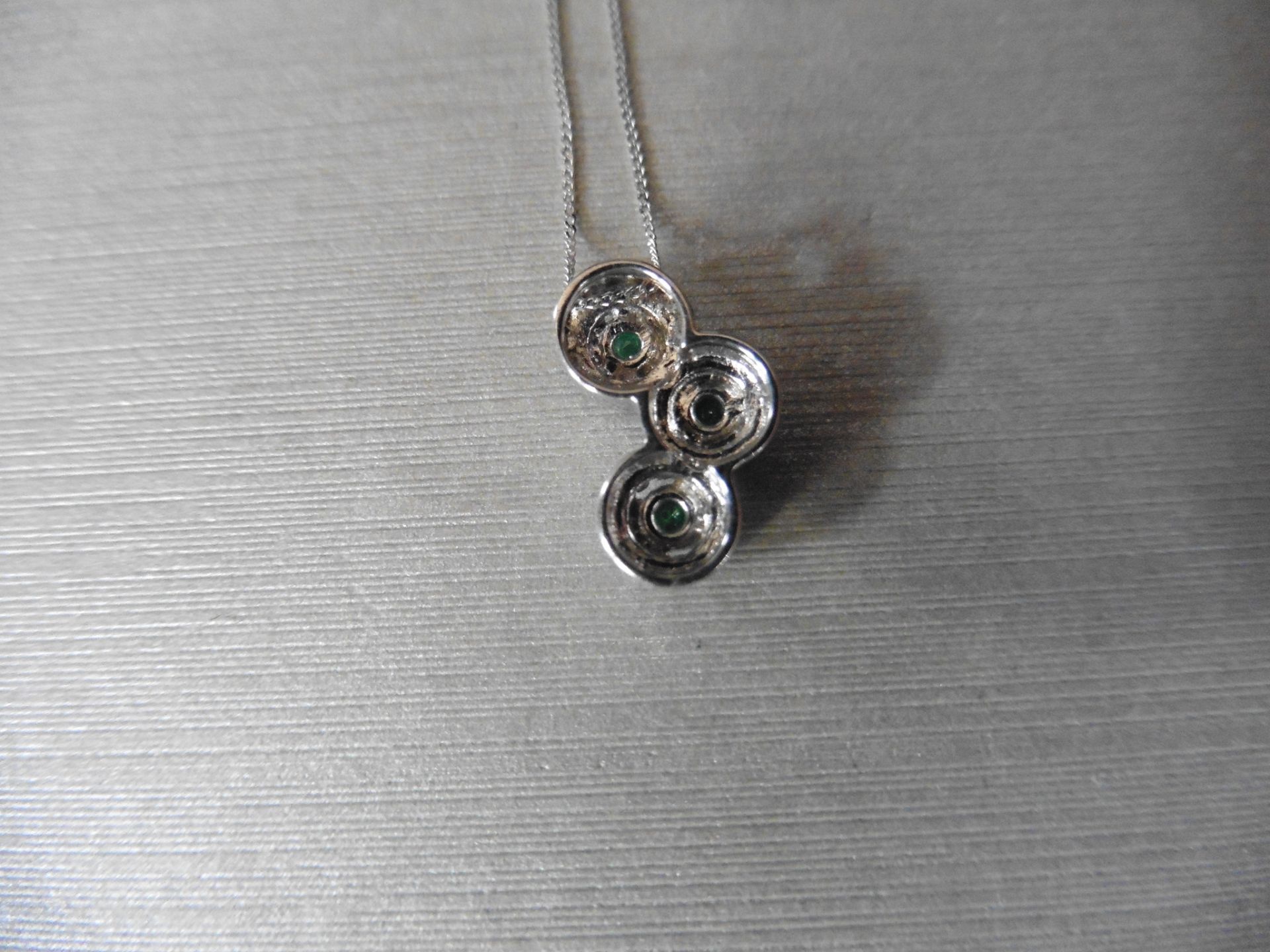 0.35ct diamond set halo trilogy style pendant. 3 centred emeralds 0.17ct total with halo setting 0. - Image 2 of 3