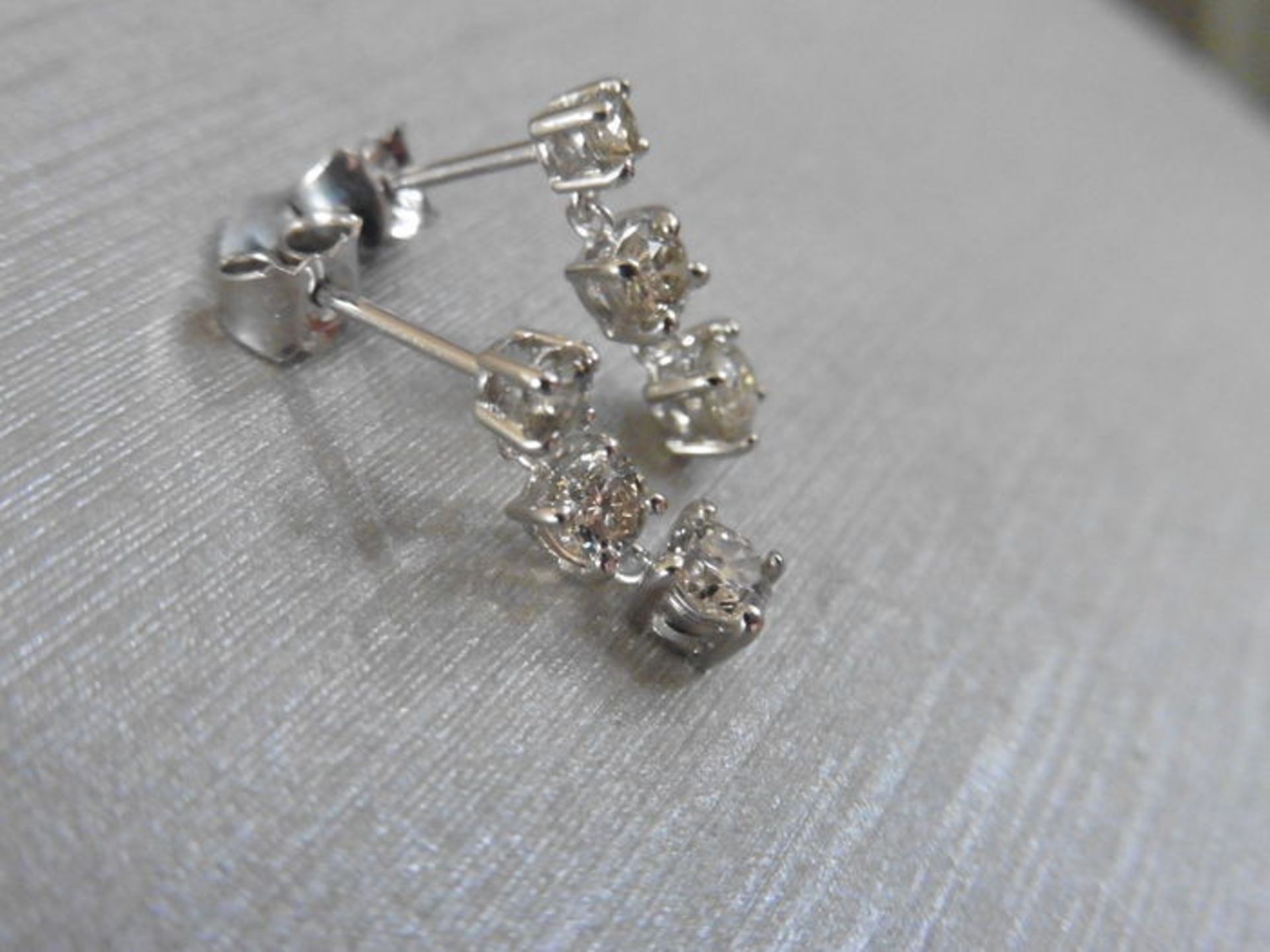 1.20ct diamond trilogy drop earrings. Each is set with 3 graduated brilliant cut diamonds, Si2