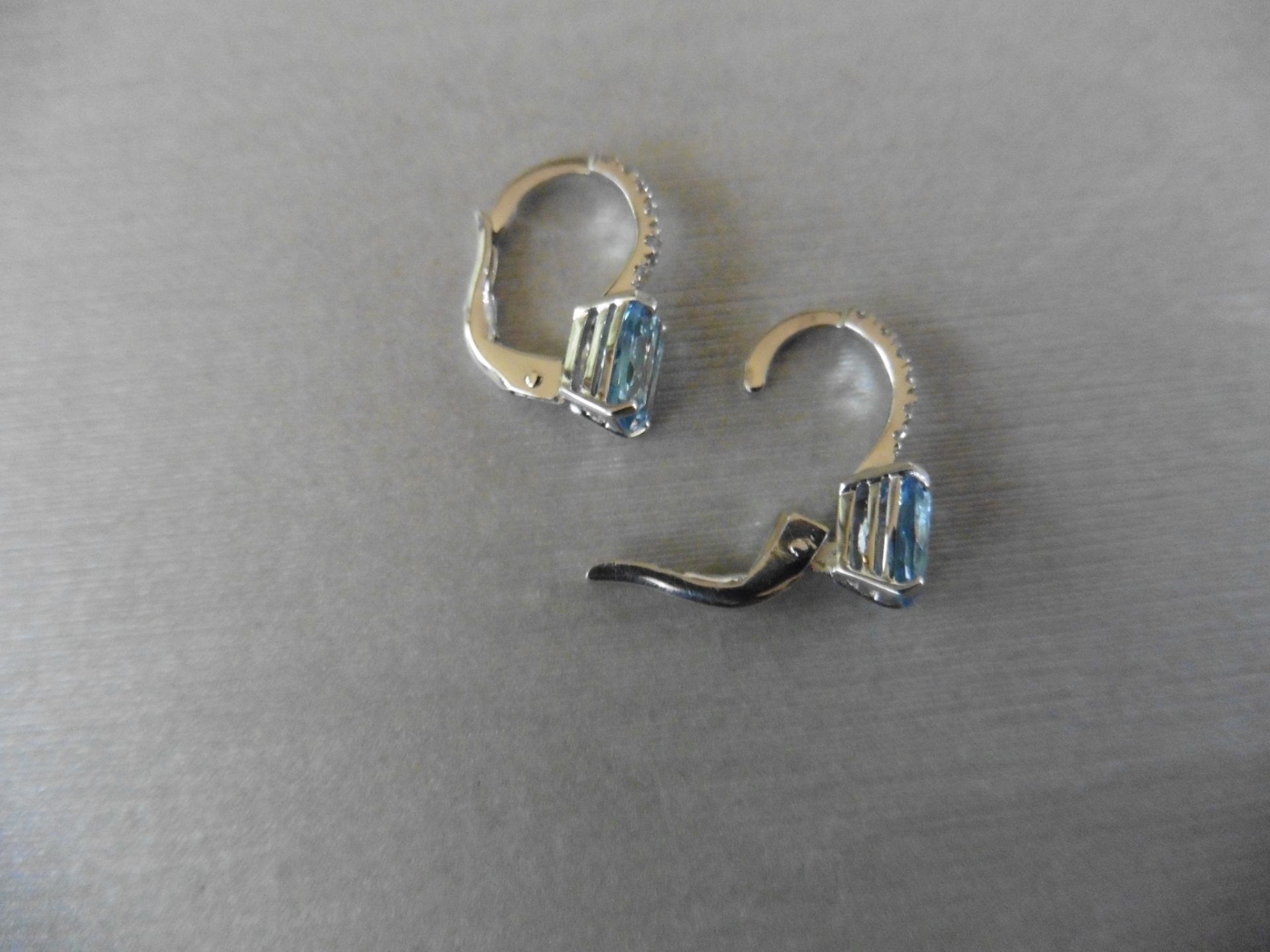 1.60ct Aqua marine and diamond hoop style earrings. Each is set with a 7x 5mm oval cut aqua with 6 - Image 4 of 4
