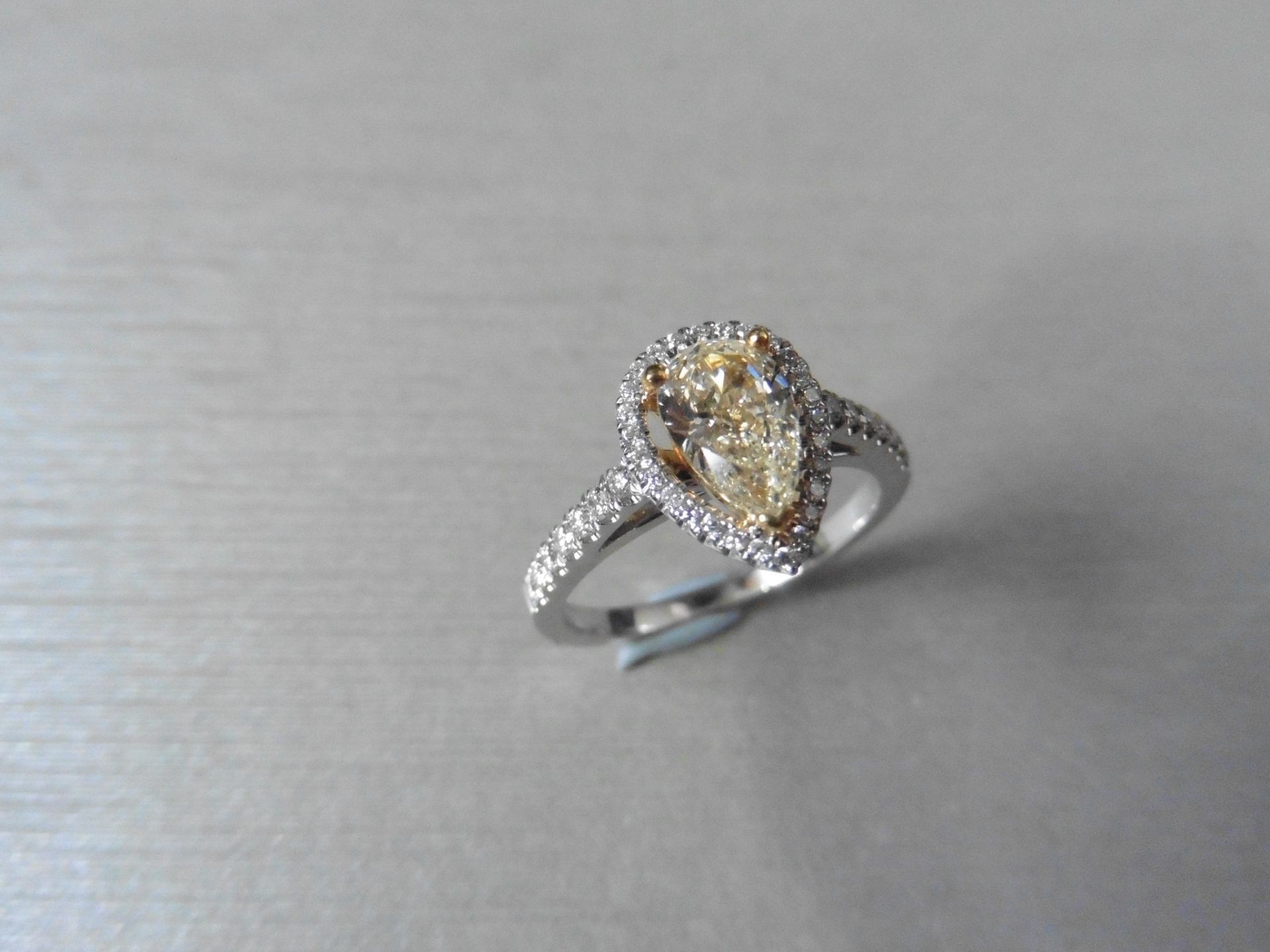 0.75ct yellow pear shaped diamond set solitaire ring. Has a halo setting of small brilliant cut