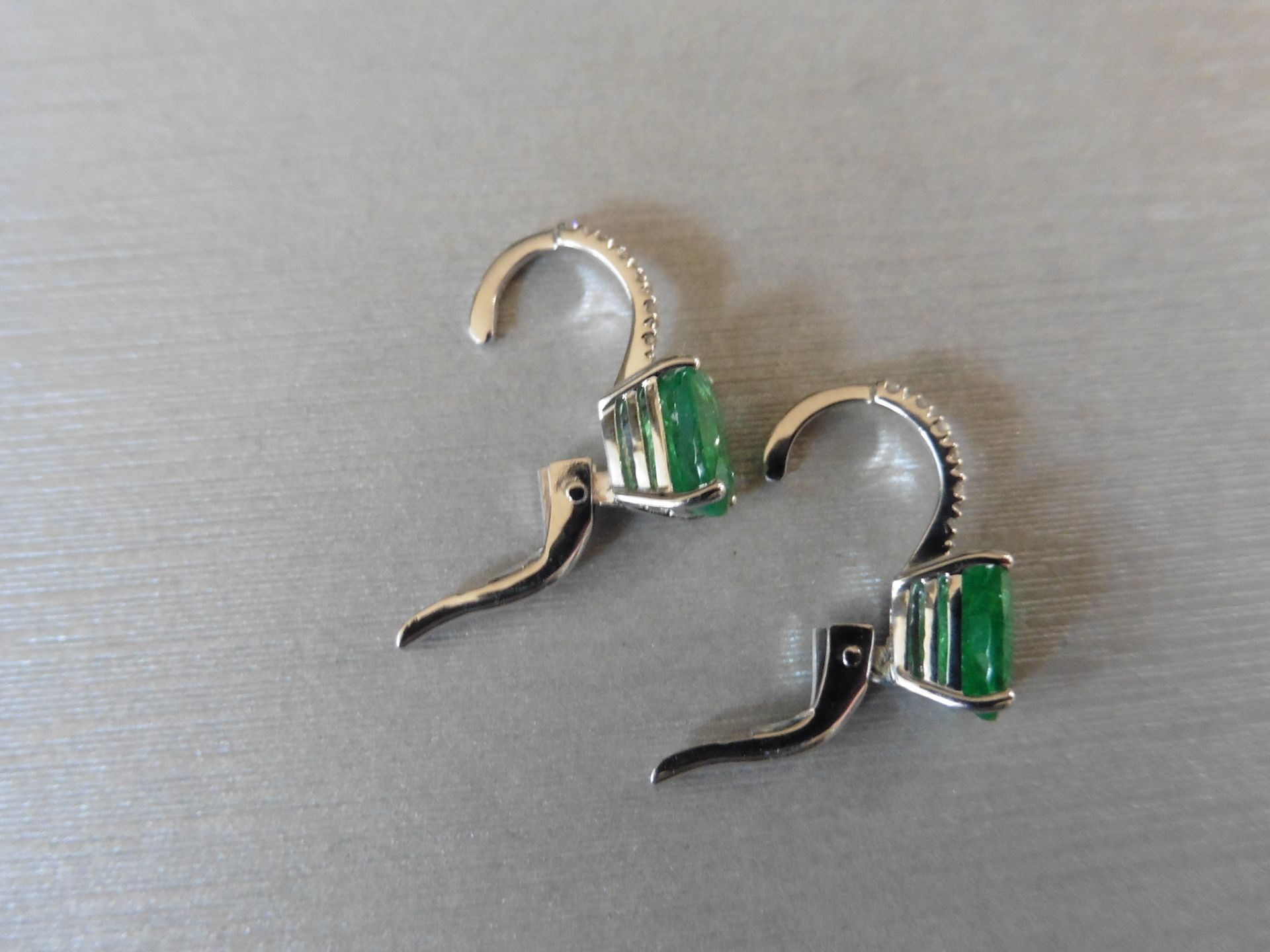 1.60ct emerald and diamond hoop style earrings. Each is set with a 7 x 5mm oval cut emerald with 6 - Image 4 of 4