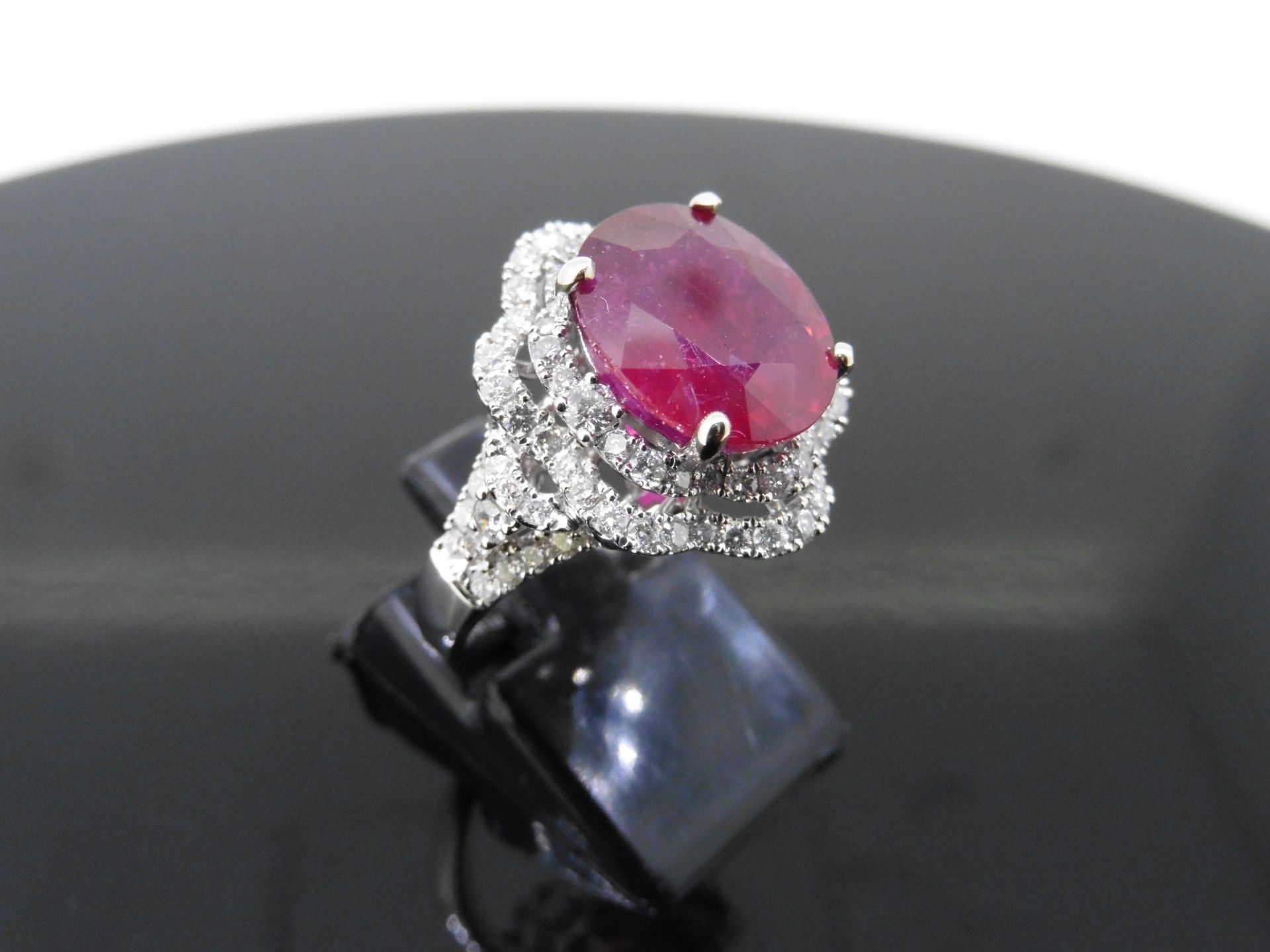 5.61ct Ruby and diamond fancy dress ring. Oval cut ruby ( treated ) set in a four claw setting