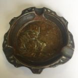 An Arts and Crafts era ash tray with repousse decoration of a man smoking a pipe. Includes free UK