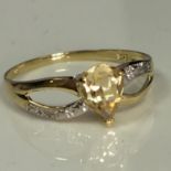 9ct gold ring (stamped 375) with an 7mm pear cut citrine solitaire stone. 0.014cts of diamond set to